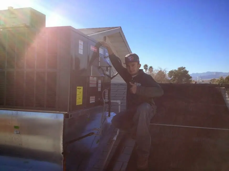 HVAC technician performing AC Tune-Up on a rooftop unit in Louisville